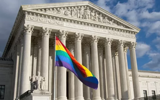 An LGBTQ+ flag flies in front of the Supreme Court. 
